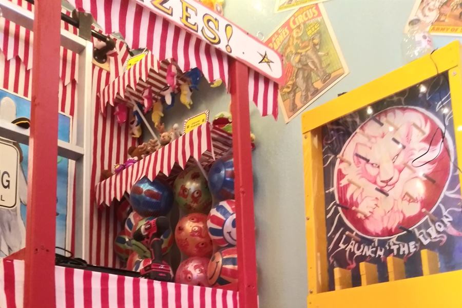 Phantom of the Big Top escape room: a red and white striped carnival game stall and a Launch the Lion arcade board
